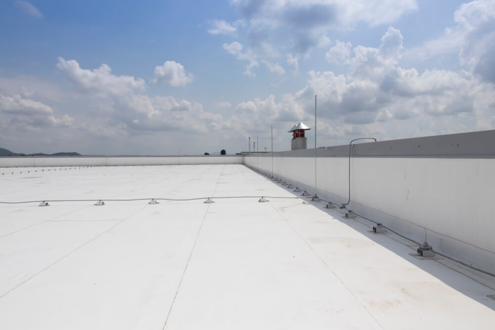 A pristine PVC roofing system atop a commercial building, with its sleek white surface reflecting sunlight