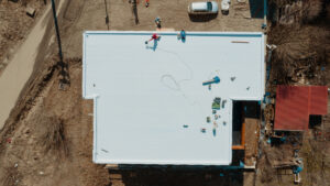 Aerial view of a PVC, flat-roofed apartment building under construction.