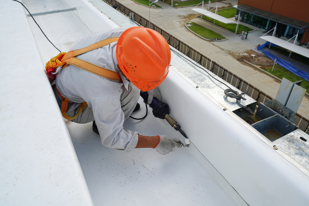 A technician welding the roof cover to the heater's retainer.