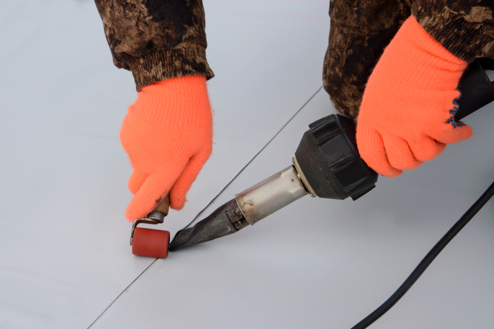Sealing process of a synthetic membrane roof with a hot air tool.