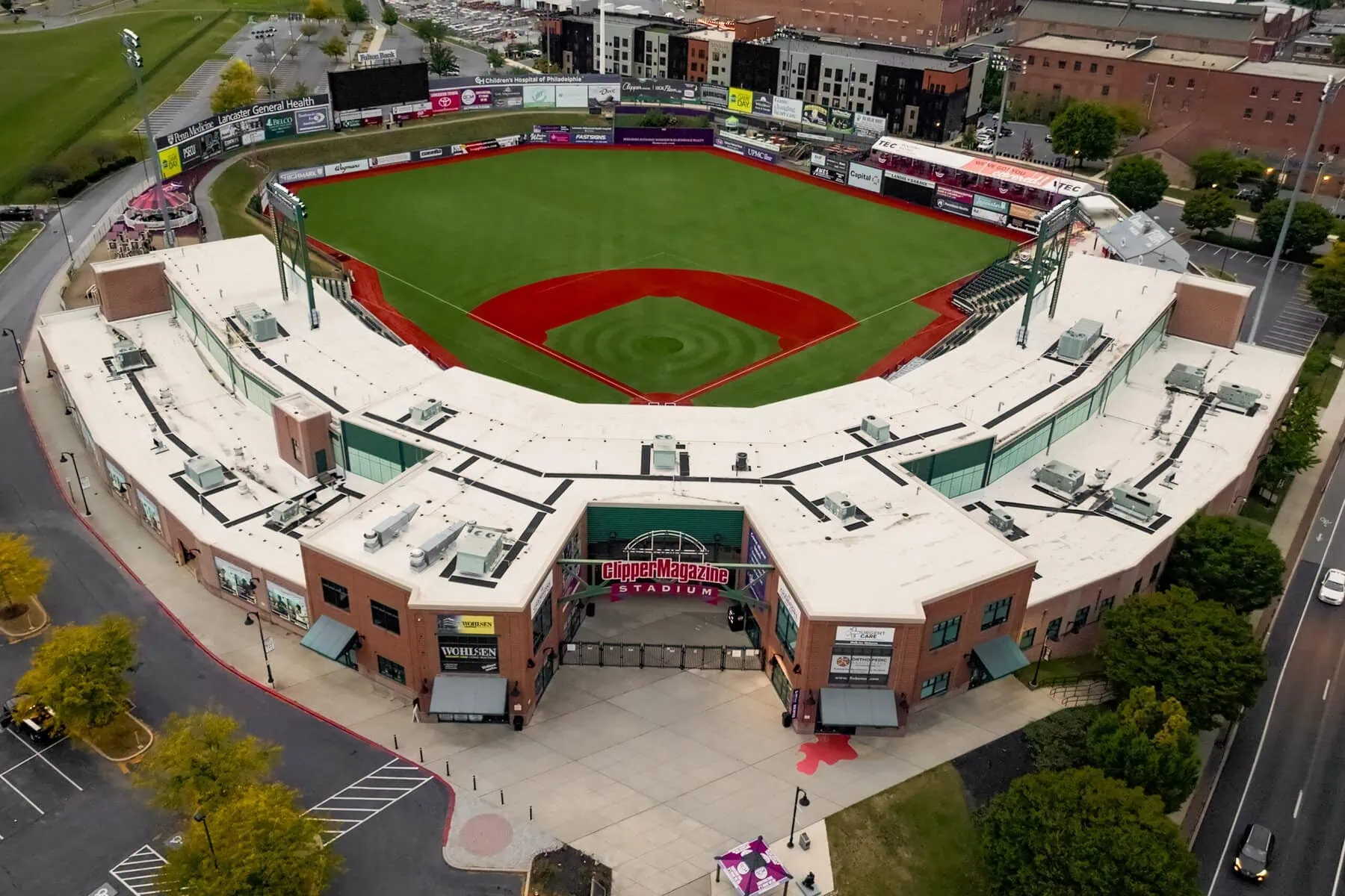 a baseball field with a large green field and a parking lot