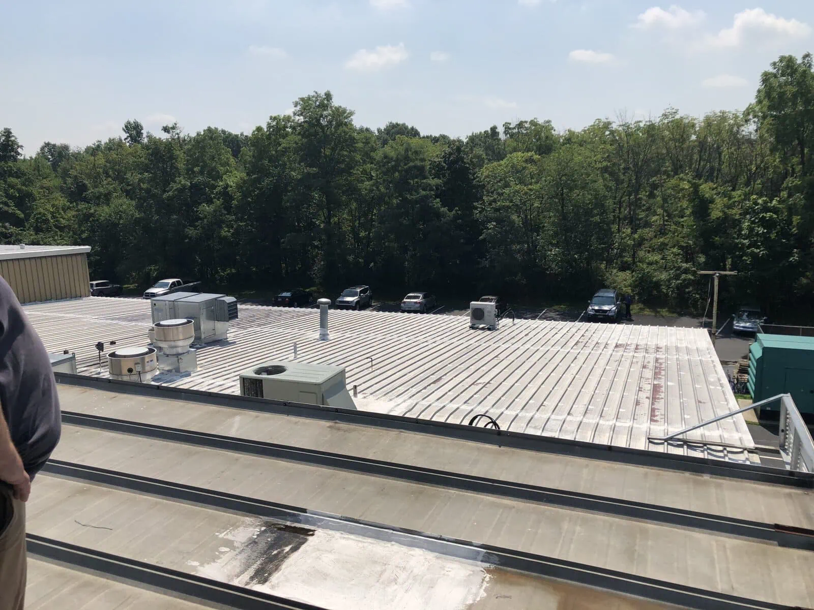 a roof with cars parked in front of trees