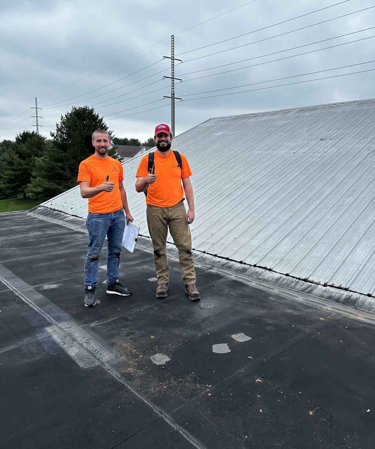 two men standing on a roof