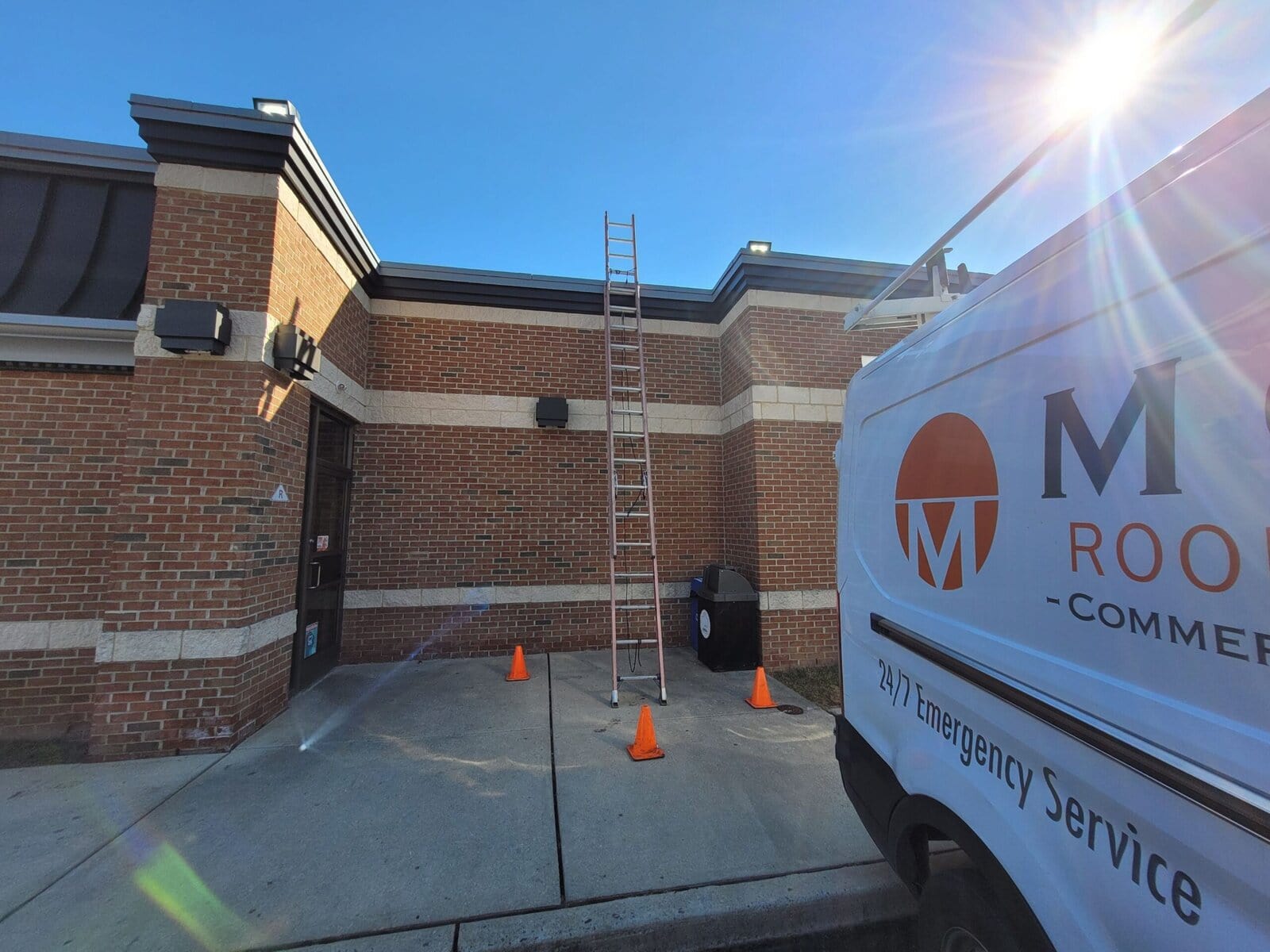 A Moser Roofing van next to a building with a ladder